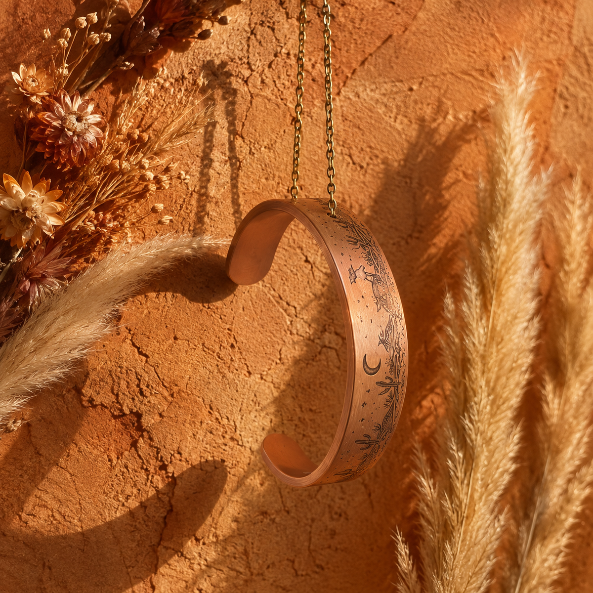 Cuivre Solange desert landscape copper cuff bracelet against a warm terracotta background