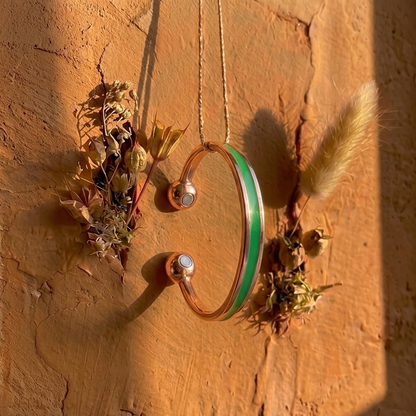 Cuivre Hortense green enamel copper cuff bracelet hanging on a terracotta wall