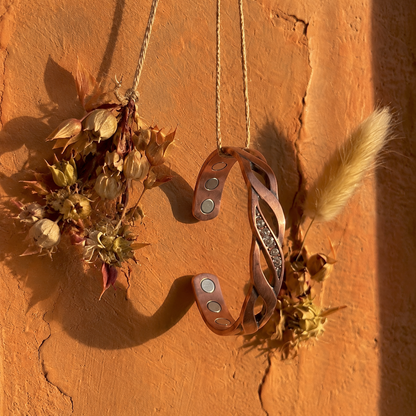 Cuivre Ysoline crystal twist copper cuff bracelet hanging on a terracotta wall