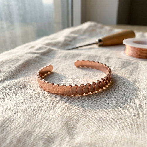Cuivre Maëlle scale copper cuff bracelet on natural linen with warm lighting