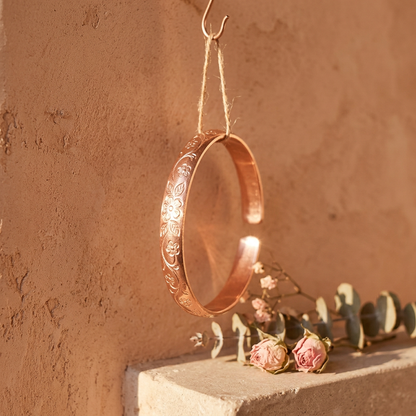 Cuivre Ninon copper cuff bracelet hanging from twine in golden hour light